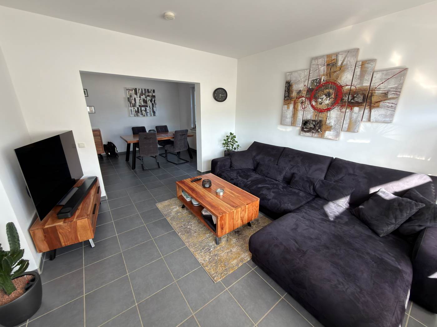 Wohnzimmer mit großer Couch und offenem Durchgang zum Essbereich