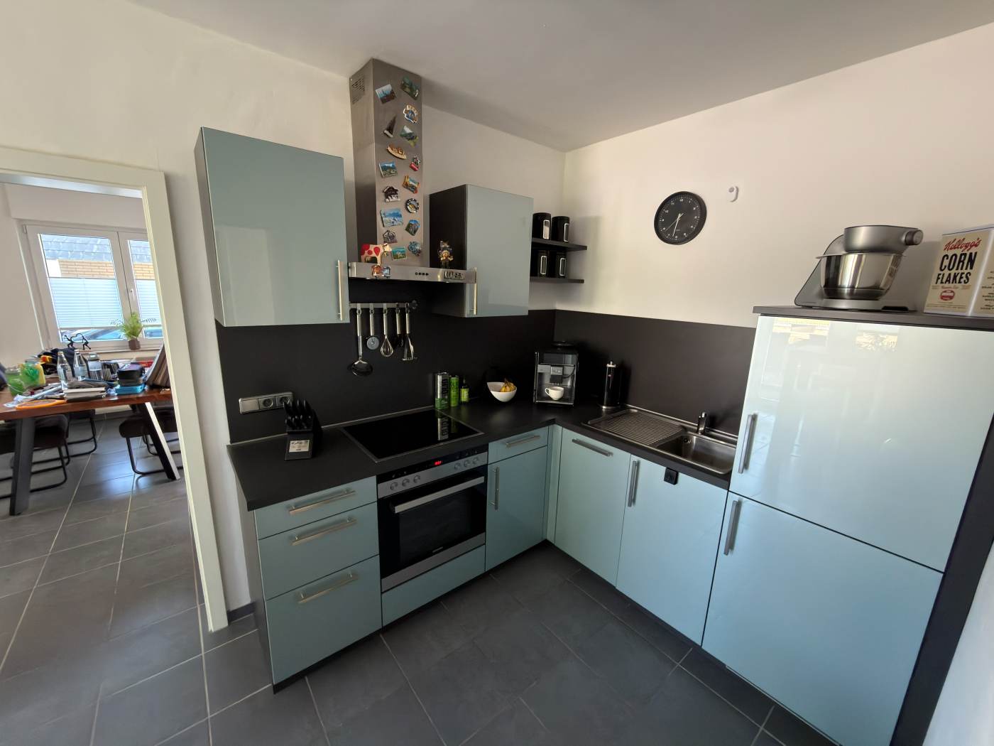 Moderne Einbauküche in Pastellblau mit dunkler Arbeitsplatte